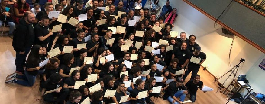 Large group of graduates holding certificates at a Mosaico event.
